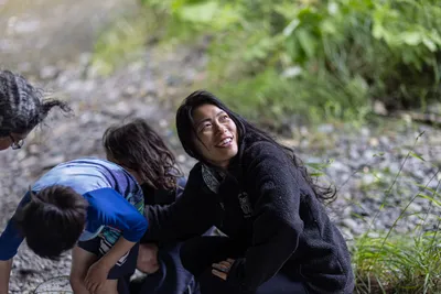 Friends including Jay Lundahl (painting with extension roller), Theresa Churchill (looking up), and others gather under a bridge to paint over hateful graffiti in Sequim, Washington on June 17, 2023.